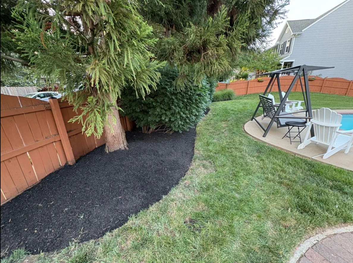 Mulched bed with hand-set stone border and white gravel accent